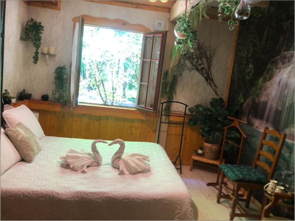 two swans sitting on a bed in a bedroom at Chambre d'hôte txaleta (le Chalet) in Saint-Priest-sous-Aixe