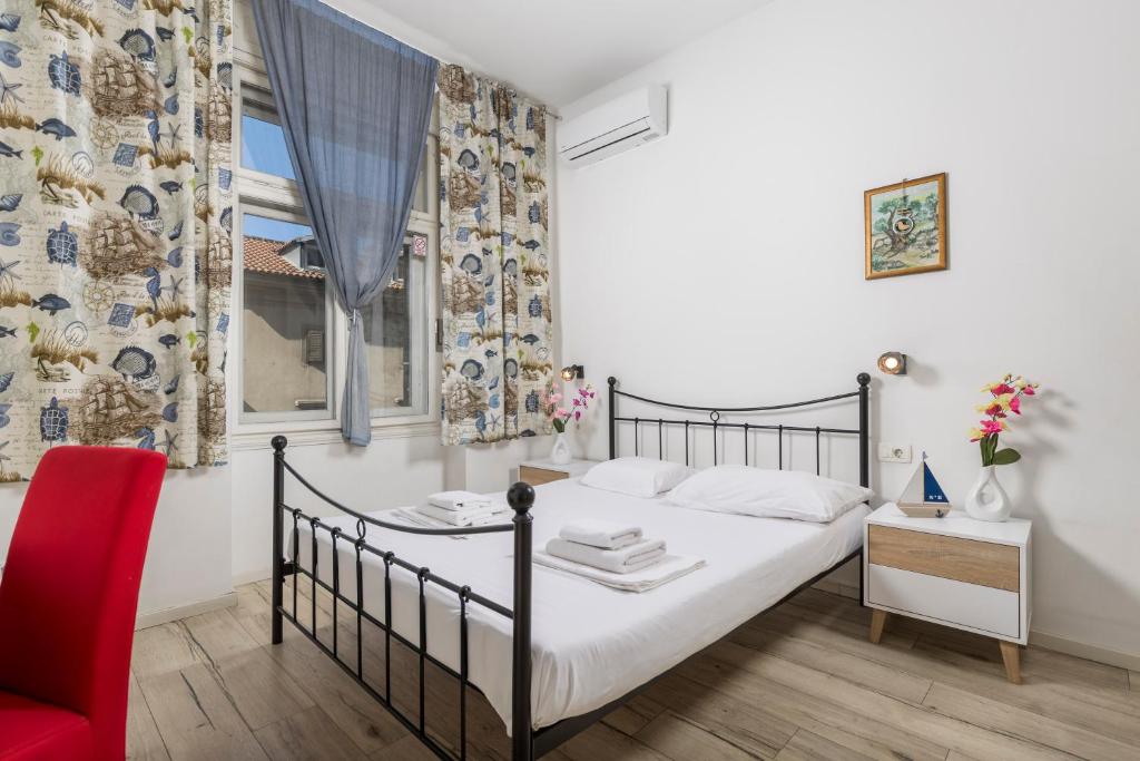 a bedroom with a bed and a red chair at Fluminis rooms in Rijeka