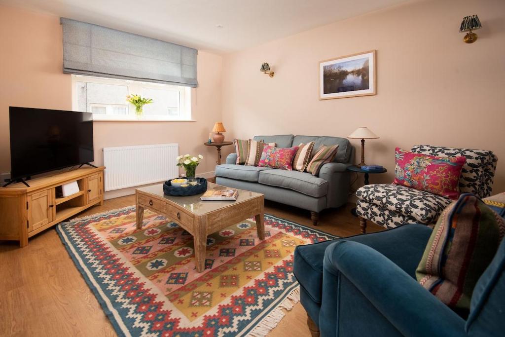 a living room with a couch and a tv at Windy Cottage, Coldstream in Coldstream