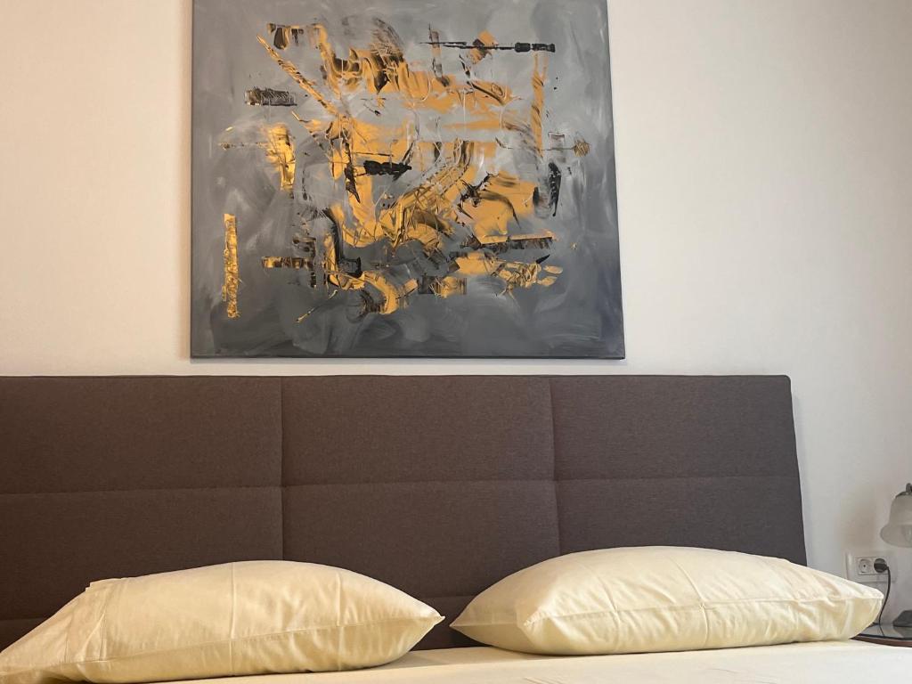 a painting hanging above a bed with a head board at Apartments Jani in Hvar