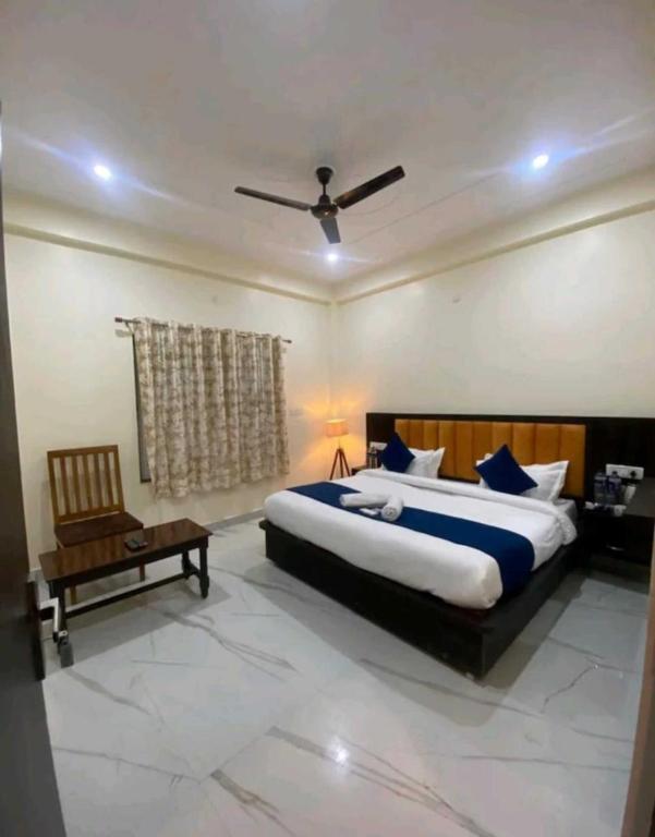um quarto com uma cama grande e uma cadeira em Hotel Nandan - 800 Metres Away From Ram Mandir Ayodhaya em Ayodhya