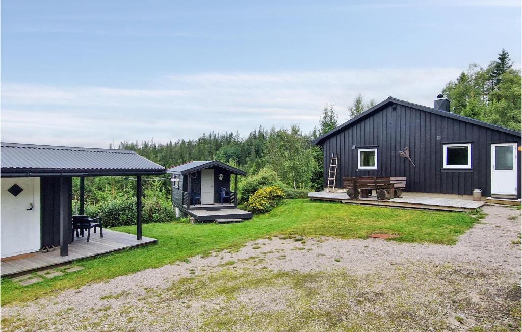 a black cabin with a picnic table in the yard at 3 Bedroom Awesome Home In Marnardal in Marnardal