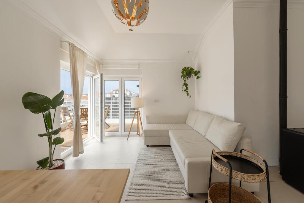 a living room with a white couch and a table at Baleal Oceanviews in Ferrel