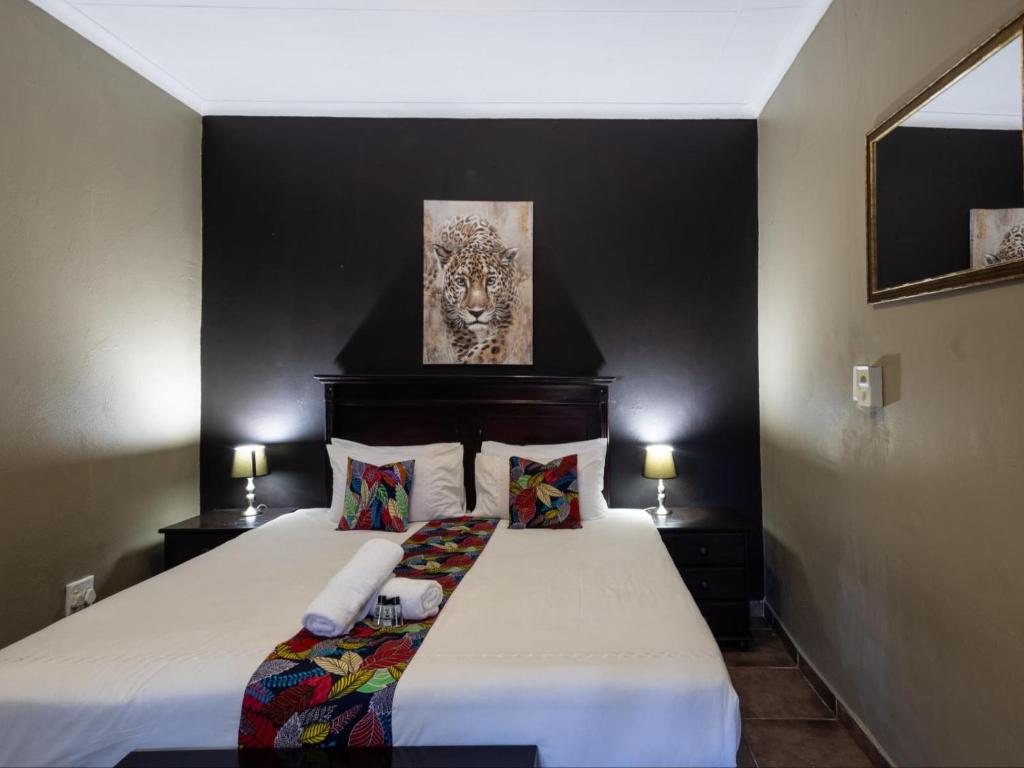 a bedroom with a bed with a painting on the wall at Eco Lodge Lephalale in Lephalale