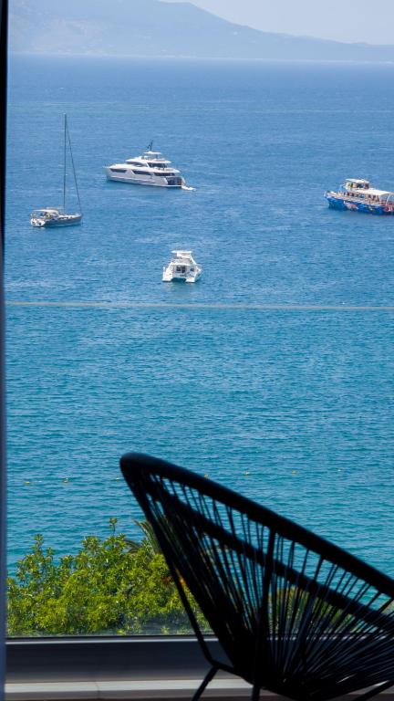 a view of boats in the water with a bench at Kanes Boutique Hotel in Sarandë