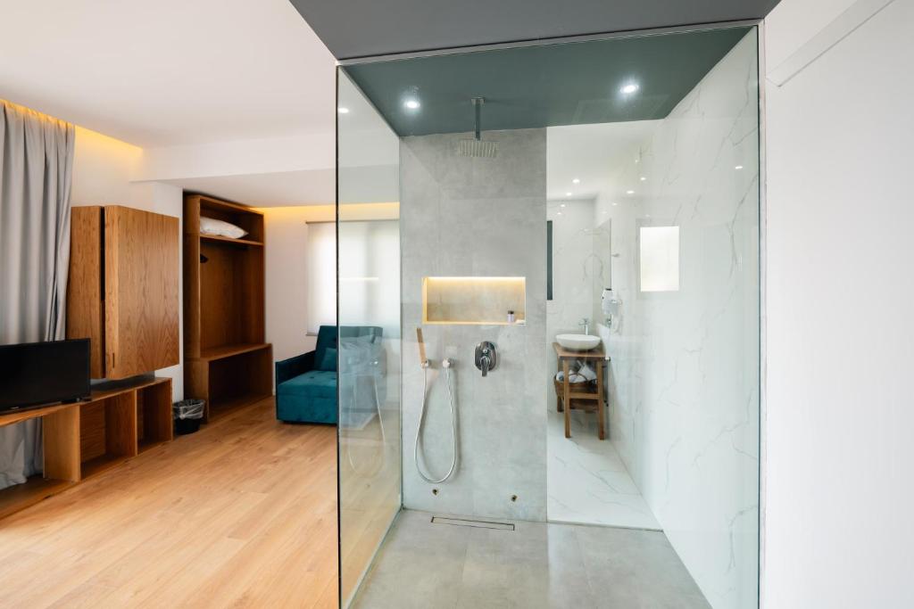 a bathroom with a shower with a glass wall at Kanes Boutique Hotel in Sarandë