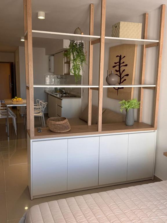 a kitchen with a large white cabinet with plants in it at Suit Chalet Santiago in Santiago del Estero