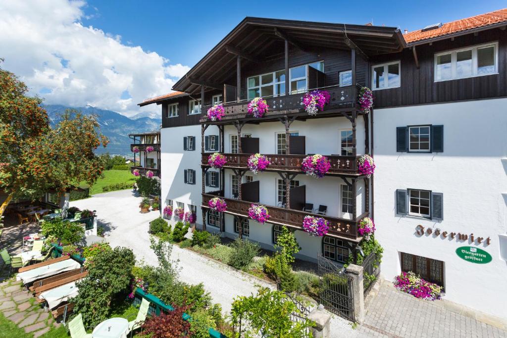 un edificio de apartamentos con flores en los balcones en Isserwirt en Innsbruck