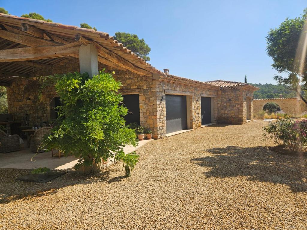 a stone house with a large yard in front of it at Coquelicot Classic Provençal House in Lorgues