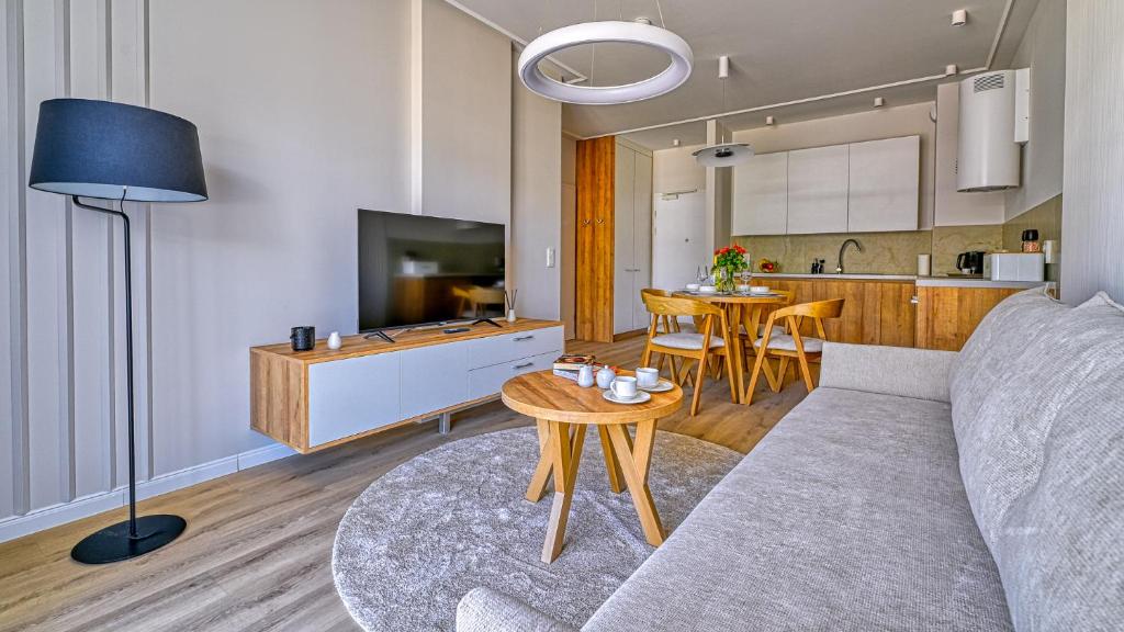a living room with a couch and a table at Rezydencja Niechorze D206 Eco Boho - 5D Apartments in Niechorze