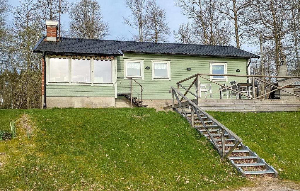a green house with a staircase in front of it at Holiday Home Mörtekull Torup in Torup