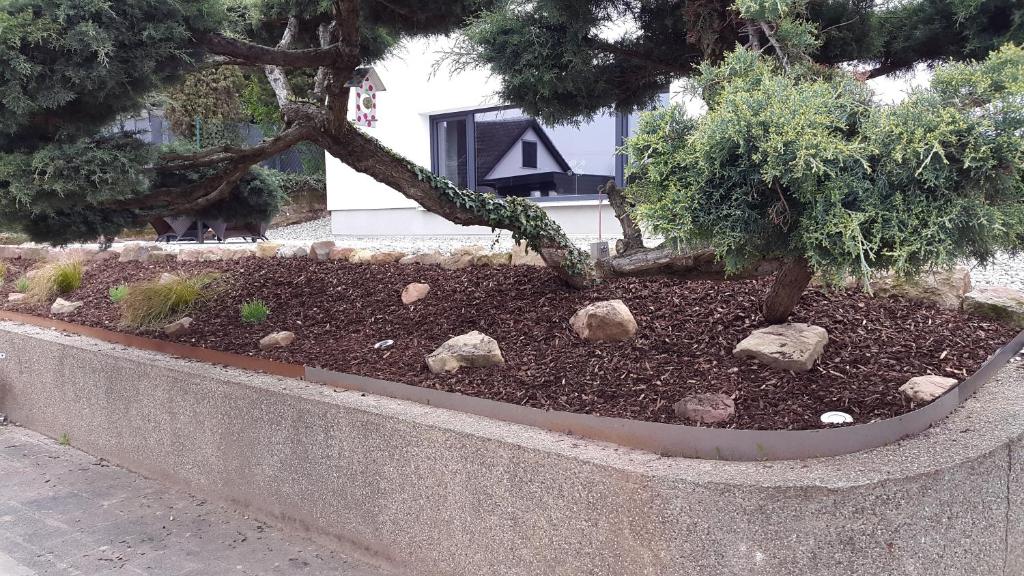 a stone planter with trees and rocks in a garden at Ferienwohnung Lotti in Burrweiler