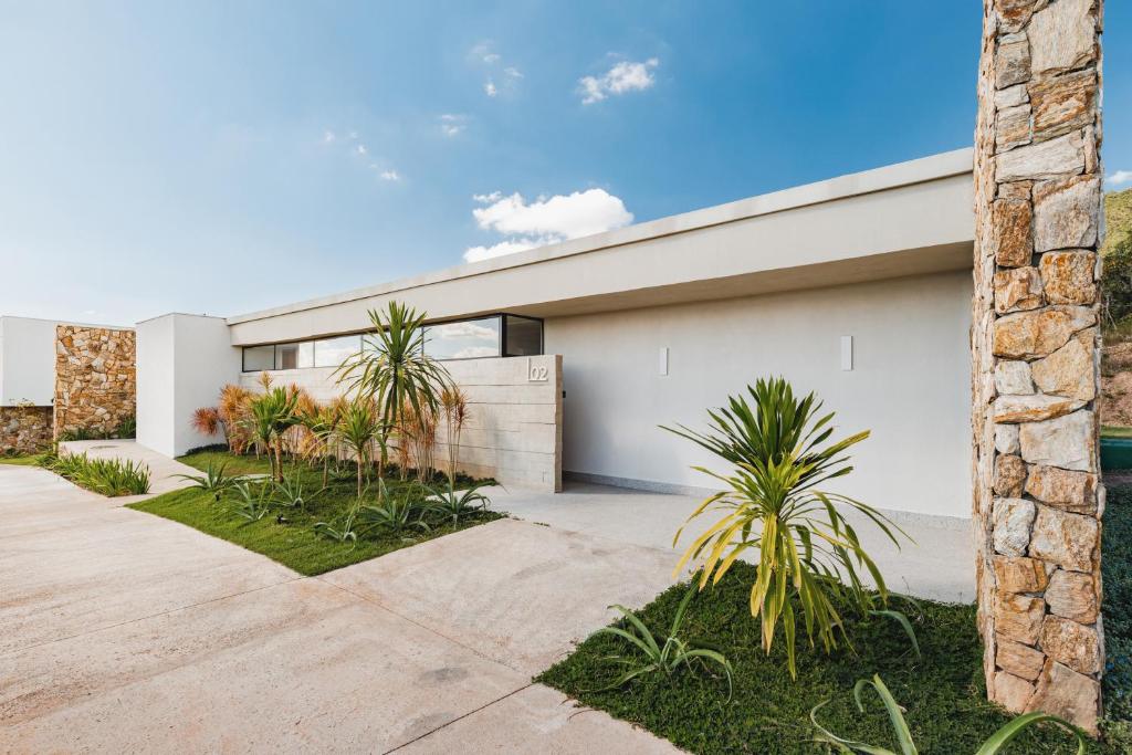 ein weißes Haus mit Palmen davor in der Unterkunft Rio Quente Resorts - Incasa Private Residence Club - Soft Opening in Rio Quente