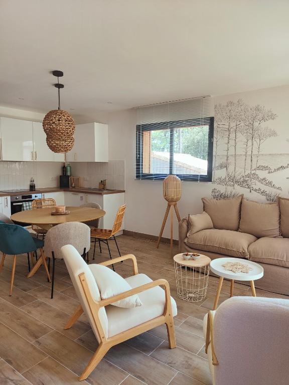 un salon avec un canapé et une table dans l'établissement Les Villas de Julie à la Maison de la Dune, à Lacanau