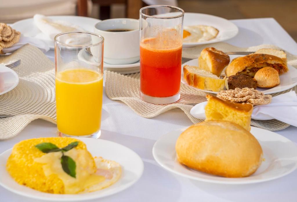 a table with plates of food and two glasses of orange juice at Aiolos Hotel & Discoveries in Prea