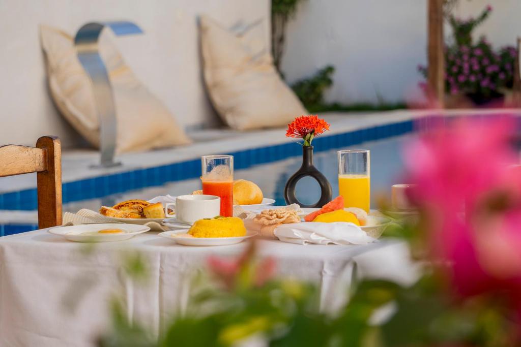 a table with breakfast foods and orange juice on it at Aiolos Hotel & Discoveries in Prea