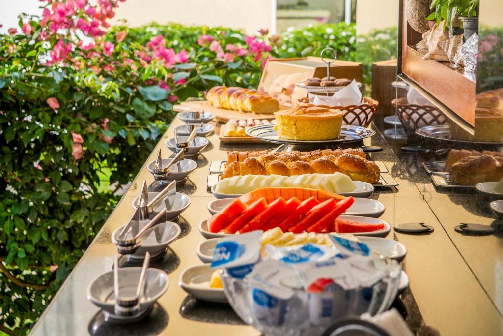 a long table with plates of food and pastries at Aiolos Hotel & Discoveries in Prea