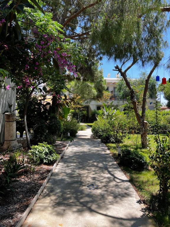 a walkway through a garden with trees and flowers at ByAKKAN HOTEL in Bodrum City