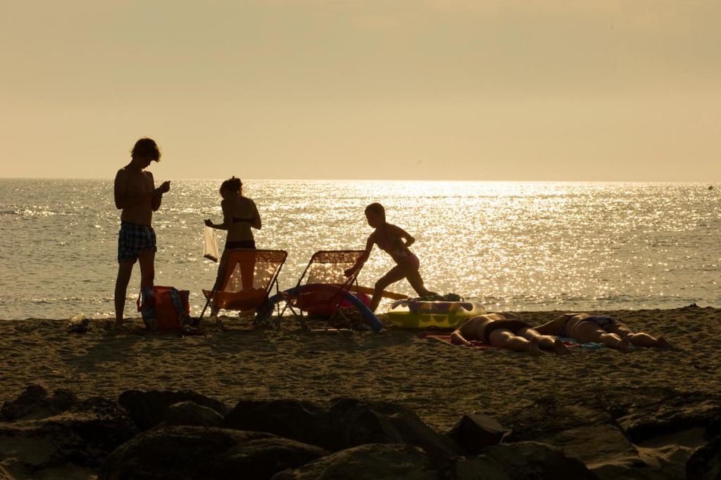 a group of people standing on the beach at Camping Le Littoral in Le Grau-dʼAgde