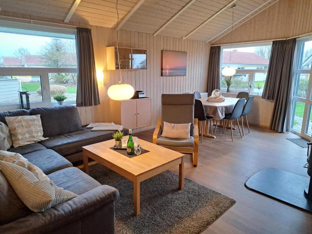 a living room with a couch and a table at 6 Personen Ferienhaus mit Sauna, Whirlpool, Kaminofen und Kanu in 2. Rheie zum See in Otterndorf in Otterndorf