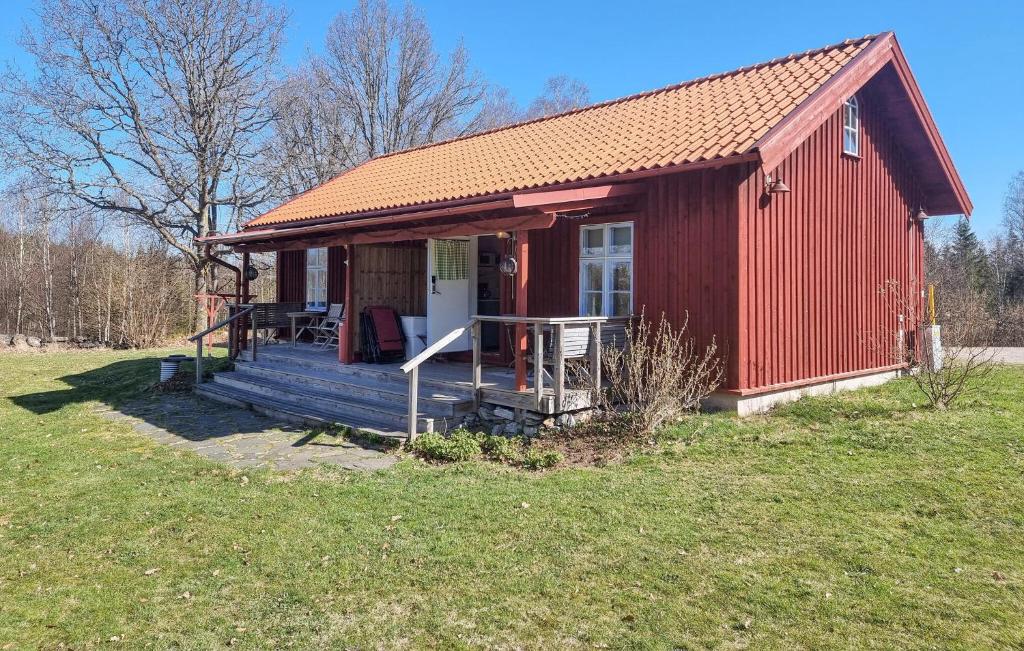 a red house with a porch and a deck at Lovely Home In Hindås With Kitchen in Hindås