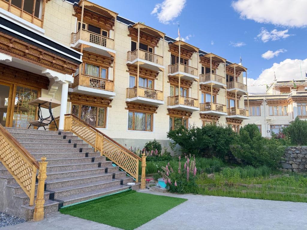 a building with stairs and grass in front of it at Raku in Leh