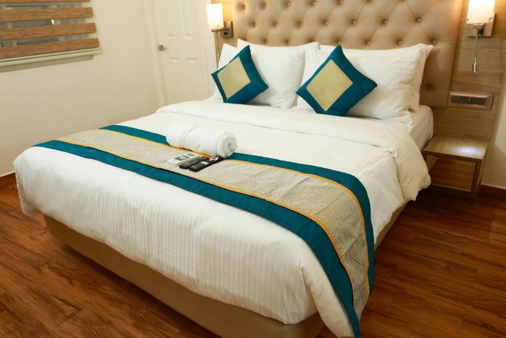 a large bed with blue and white sheets and pillows at Luxos by Proximus in Bengaluru