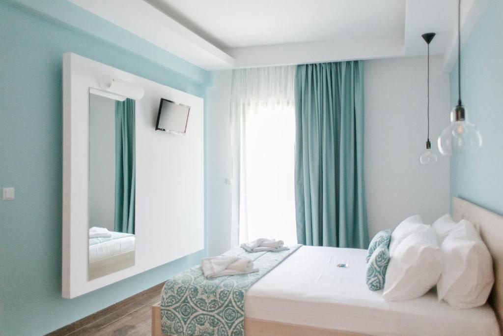 a bedroom with a bed with a mirror and a window at Anastasia Rooms in Skala Potamias
