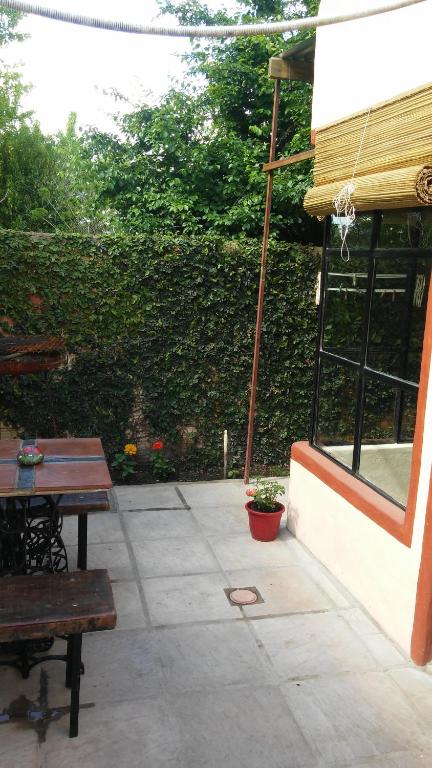 een patio met 2 banken, een tafel en een raam bij Casa de Olga in Tandil