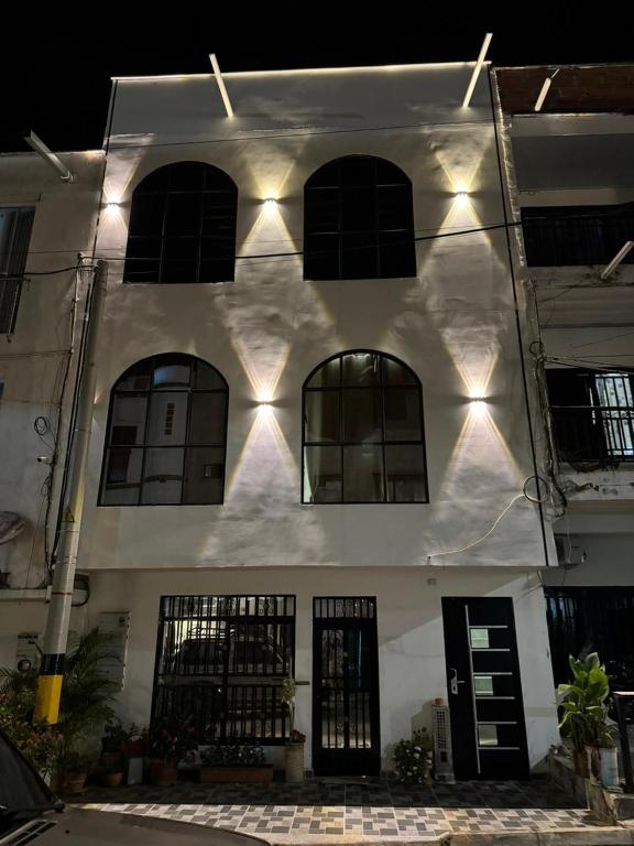 un edificio blanco con ventanas y luces. en Habitaciones en Doradal 202, en Doradal
