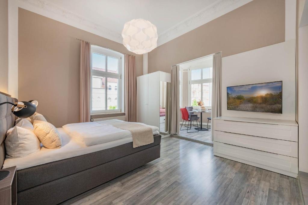 ein Schlafzimmer mit einem Bett und einem Fernseher an der Wand in der Unterkunft Villa Carmen Strandkorb in Ahlbeck