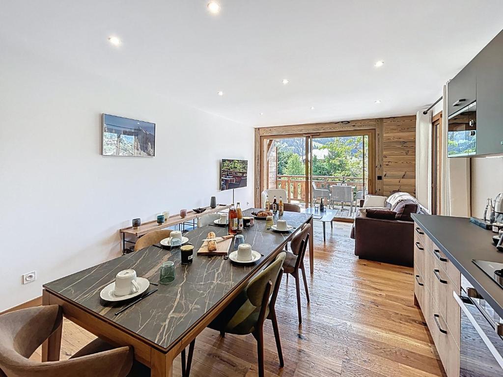 une cuisine et une salle à manger avec une table et des chaises dans l'établissement Tamaris - Morzine - secteur Planet, à Morzine