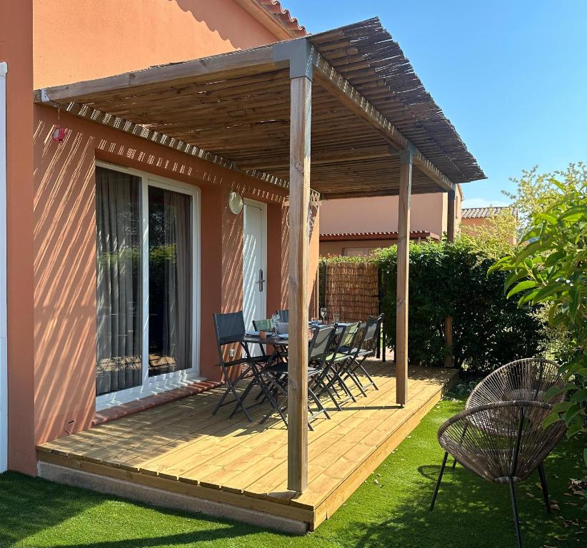 une terrasse en bois avec une table et des chaises dessus dans l'établissement Mini Villa 4-6 pers. Les hameaux de Saint Cyprien, à Lecci