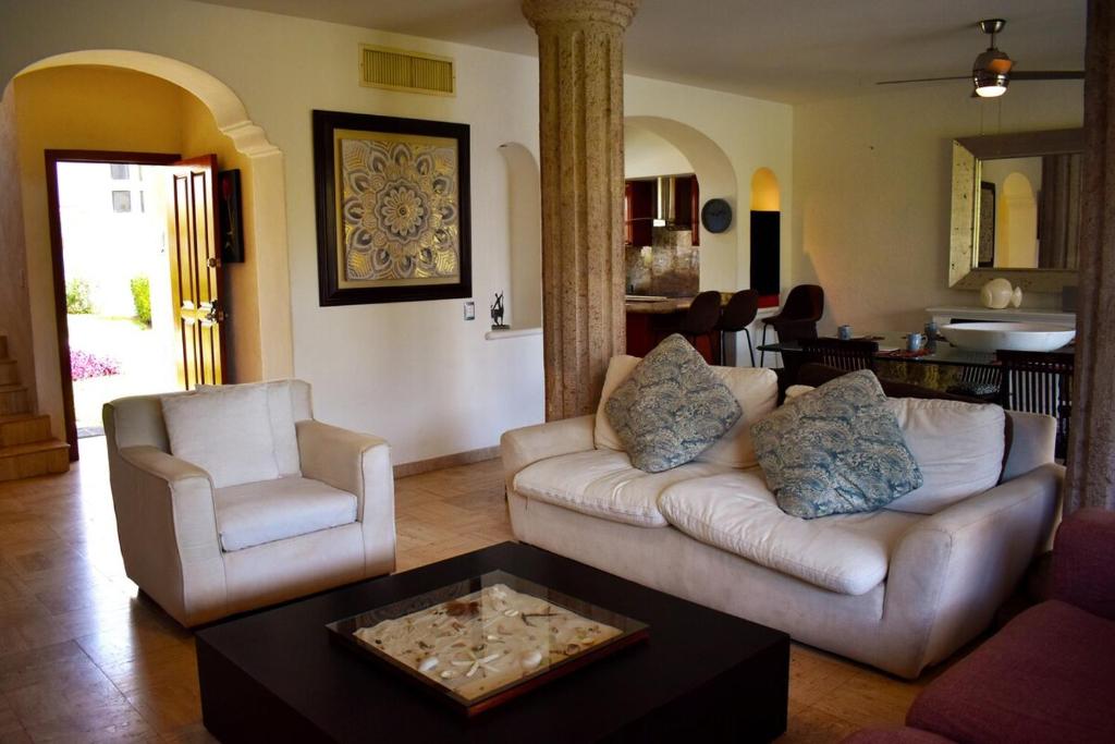 a living room with a couch and two chairs at Vidanta Villas Golf - Jacuzzi, Alberca, Lago in Acapulco