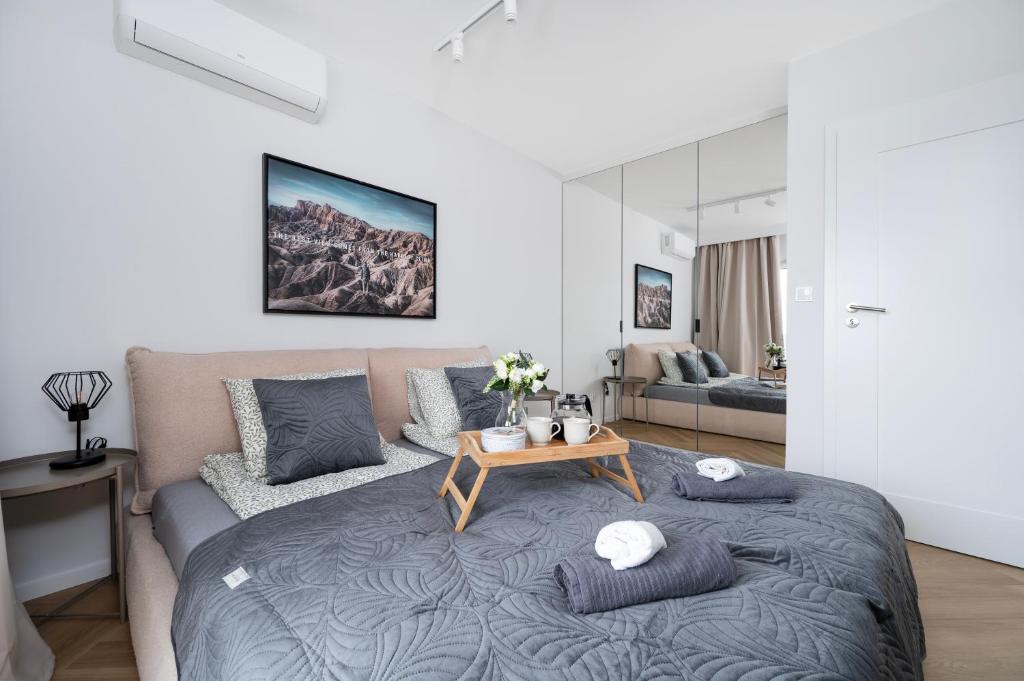 Manufaktura Suites - 76m2, Parking, AirCon - by Rentujemy في لودز: غرفة نوم بسرير ومخدات وطاولة