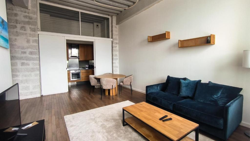 un salon avec un canapé et une table dans l'établissement Superbe Appartement Rue Royale - Gregoire, à Lille