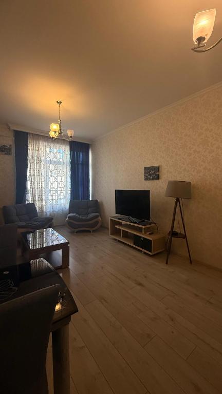 sala de estar amplia con TV de pantalla plana. en Family Accommodation, en Tiflis