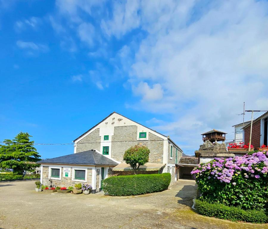a house with flowers in the driveway at Casa Choureiro Apartamentos Rurales in Navia