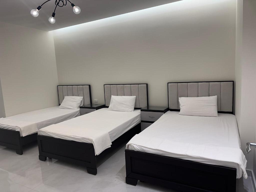 zwei Betten in einem Zimmer mit weißen Wänden in der Unterkunft Water Front Luxury in Jnah Beirut 