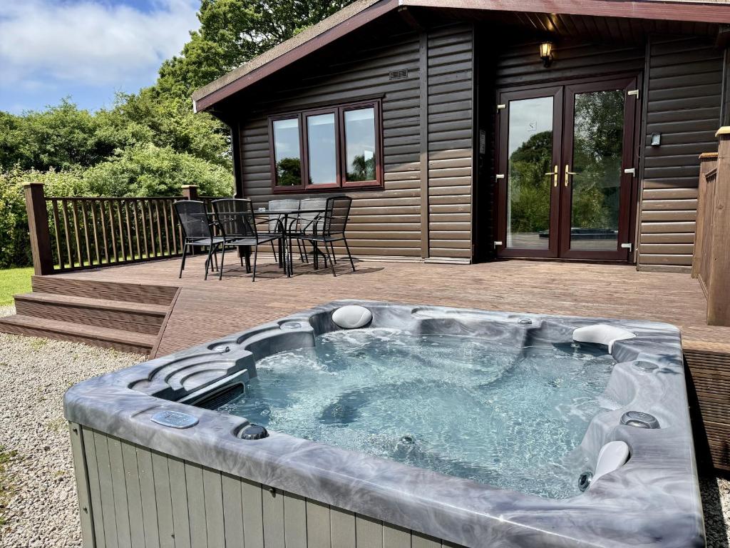a hot tub in front of a house at Willow Lodge in Falmouth