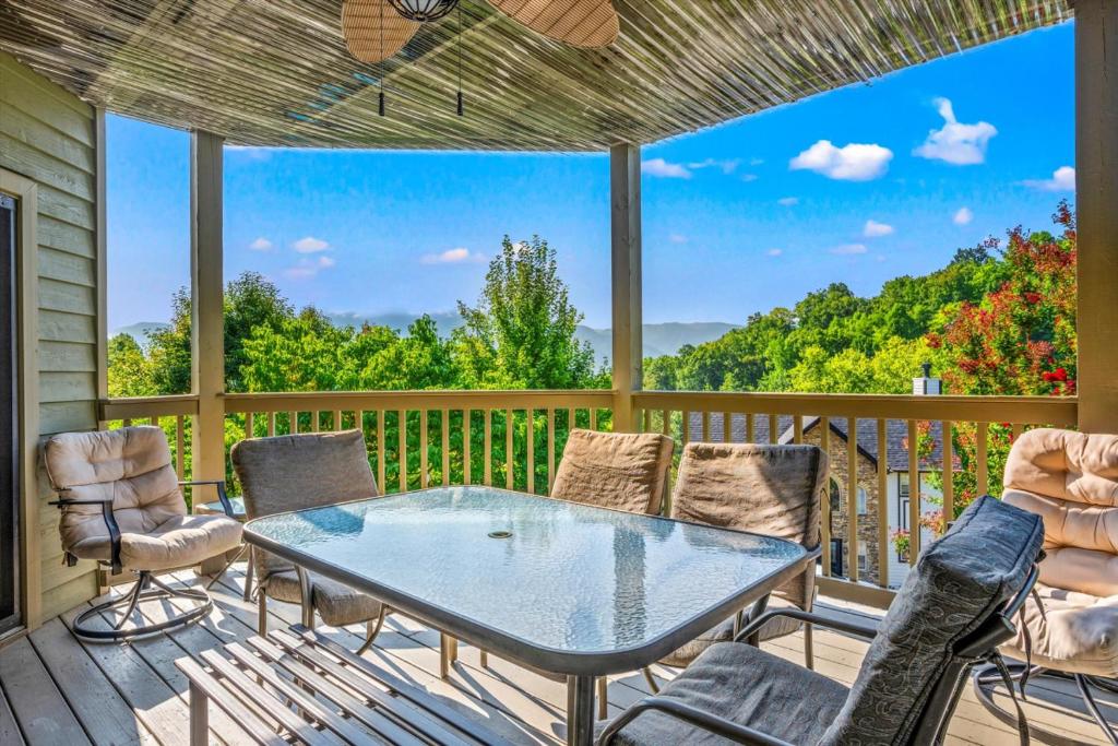 a patio with a table and chairs on a deck at Mountains 4 Miles By Avada Properties in Gatlinburg