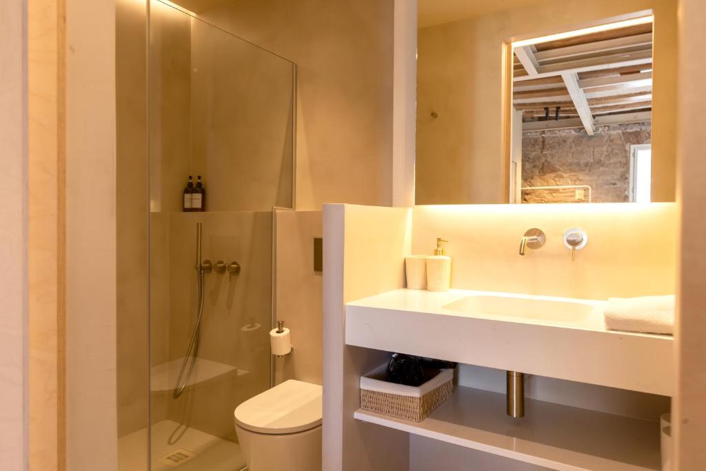a bathroom with a sink and a shower and a toilet at Decô Apartments Barcelona-Born St. in Barcelona
