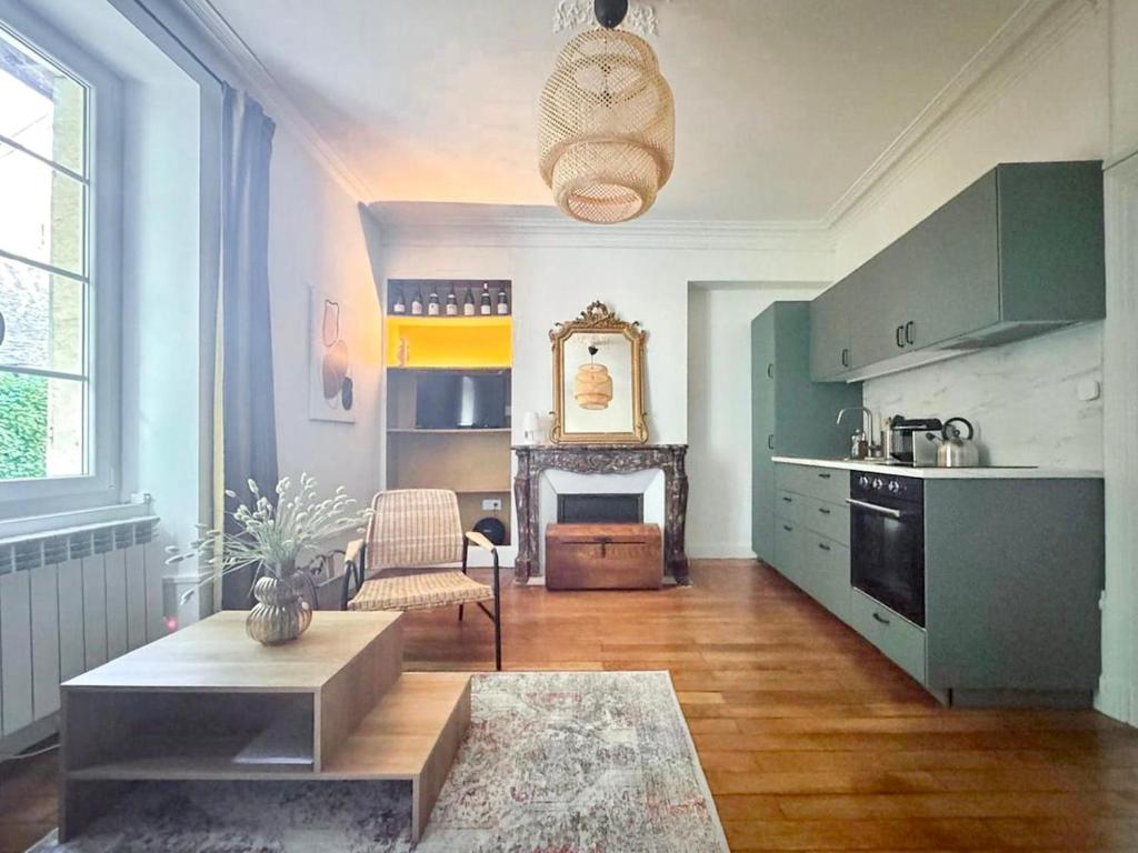 a kitchen with green cabinets and a living room at Appartement au Grain d' Moutarde in Dijon