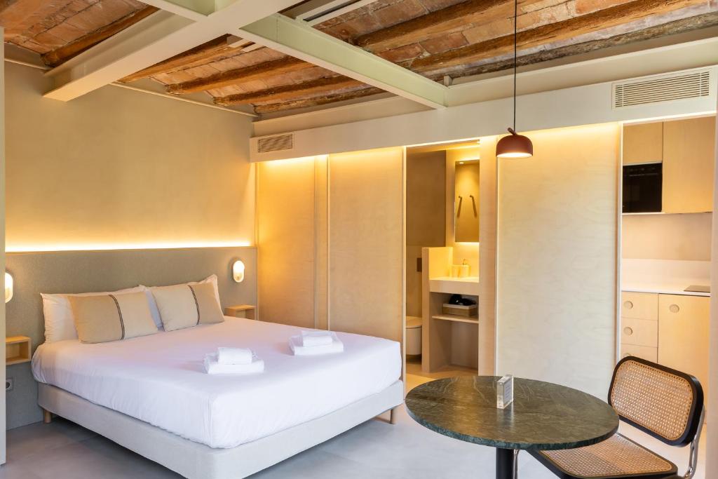 a bedroom with a white bed and a table at Decô Apartments Barcelona-Born St. in Barcelona