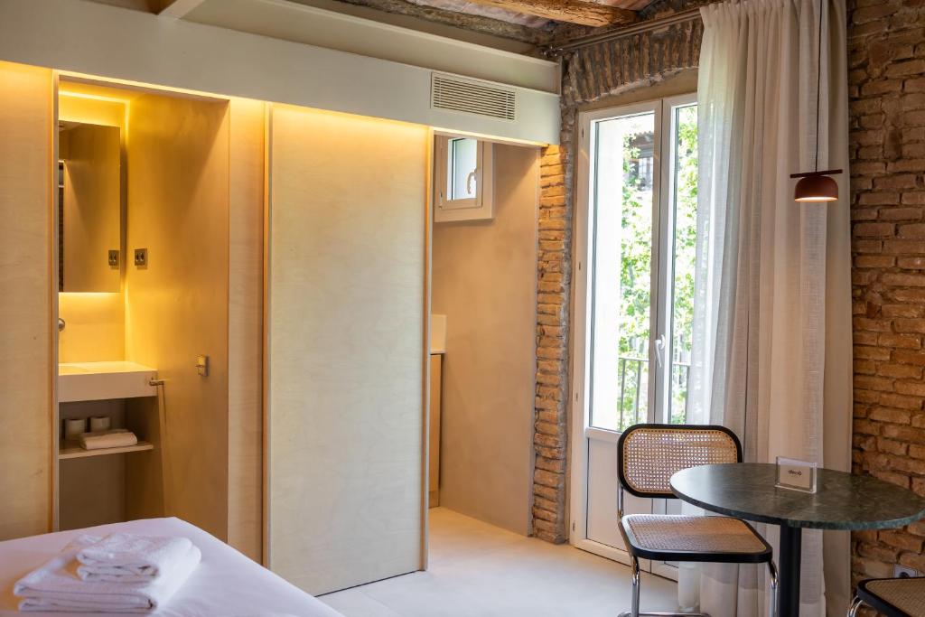 a room with a bed and a table and a window at Decô Apartments Barcelona-Born St. in Barcelona