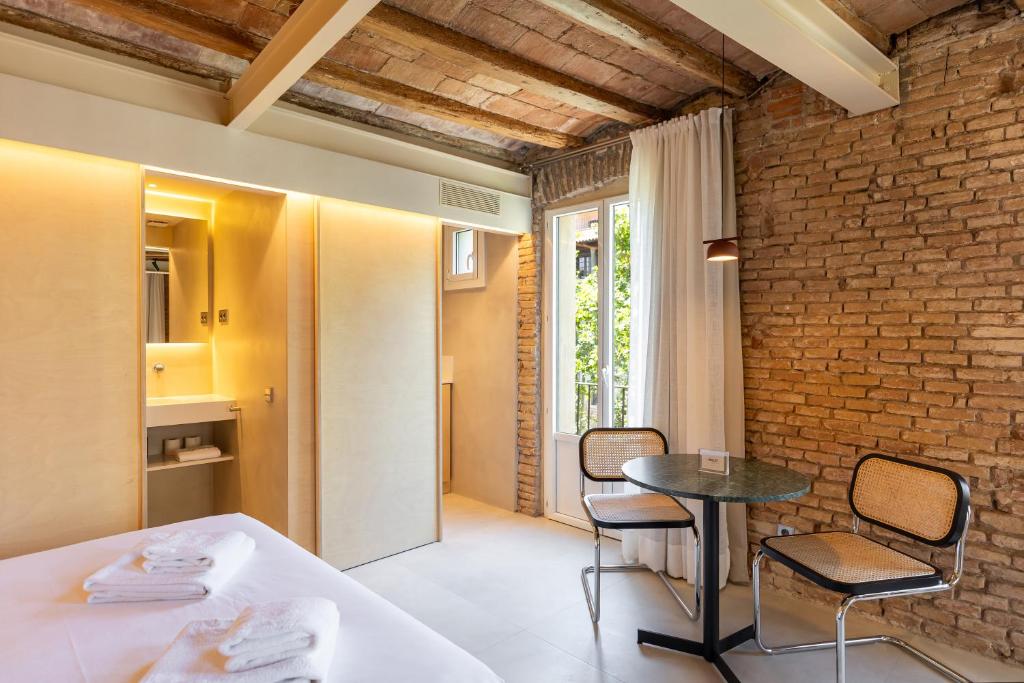 a room with a table and chairs and a brick wall at Decô Apartments Barcelona-Born St. in Barcelona