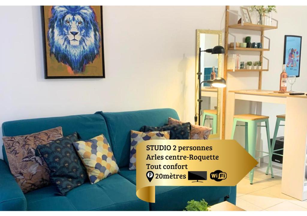 un canapé bleu avec une pancarte dans un salon dans l'établissement Studio Sérénité-La Roquette-Rue très calme, à Arles