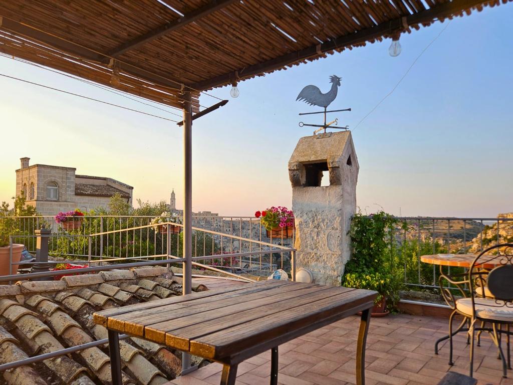 een terras met een houten tafel en een vogel op een vogelhuisje bij La Suite Delle Stelle in Matera