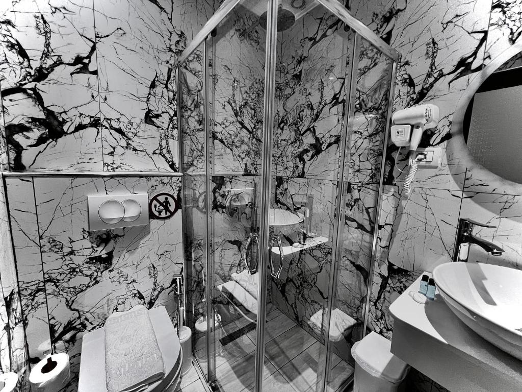 a bathroom with a shower and a toilet and a sink at Dine Hotel in Ksamil