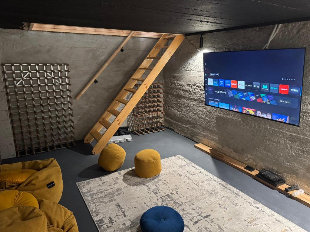 a room with a tv and a ladder and a table at Leśna in Ostróda